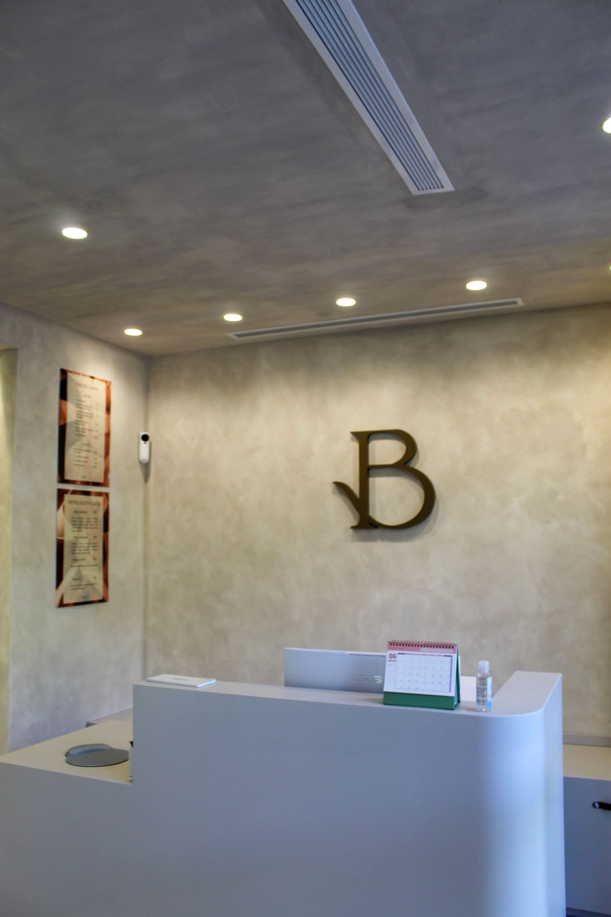 Recepción de Clínica Bera con el monograma de la marca en la pared