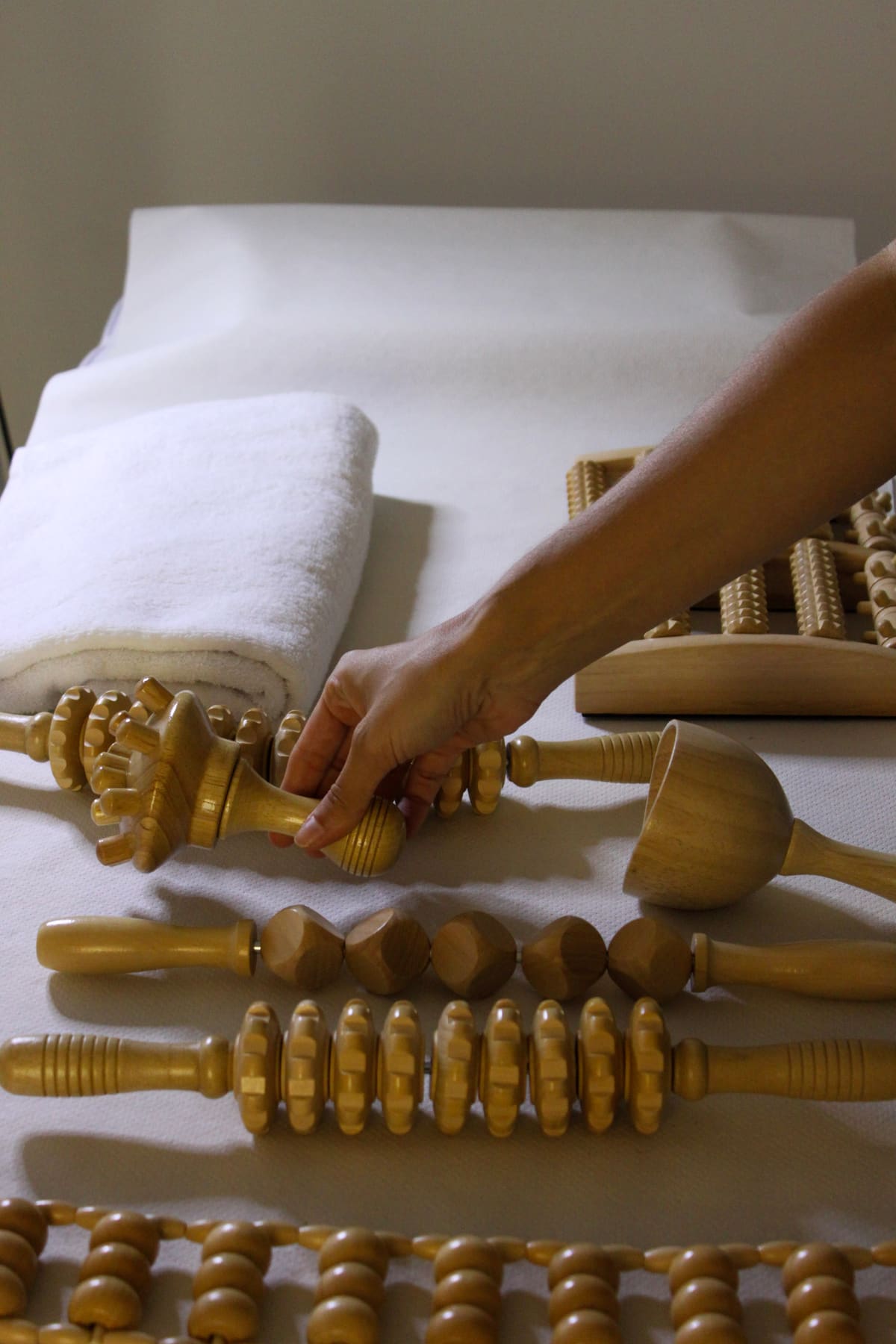 Utensilios de madera para maderoterapia preparados en la camilla